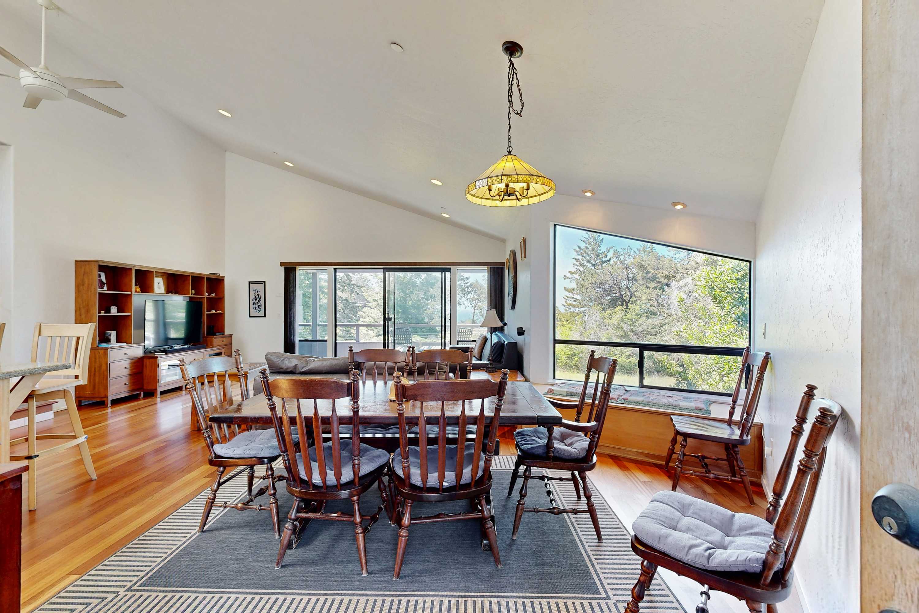 Gather around the large dining table for unforgettable meals, with sunlight streaming in and nature just outside the window.