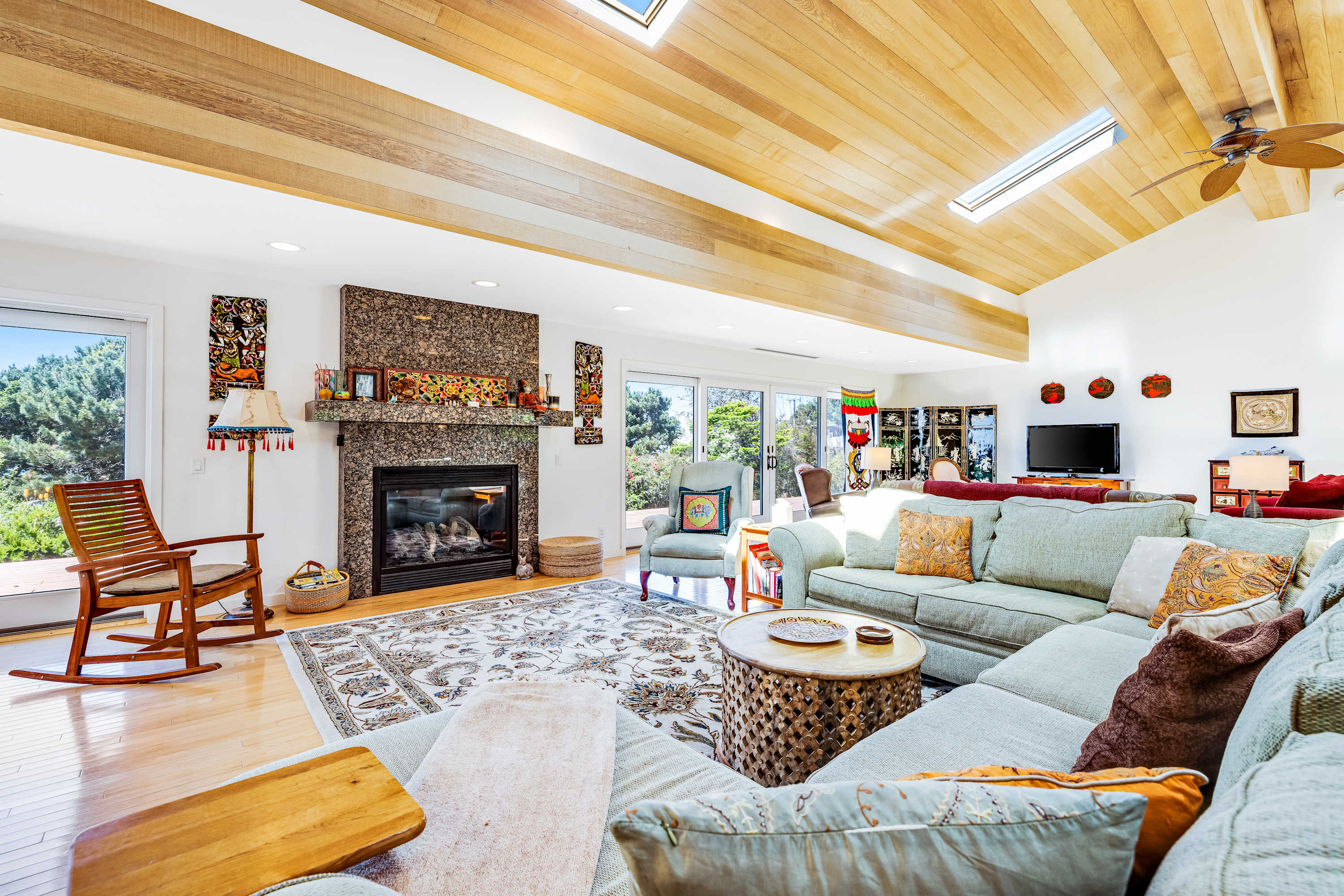 Gather in the spacious living room, where natural light dances off the wood beams and the gas fireplace invites cozy conversations.