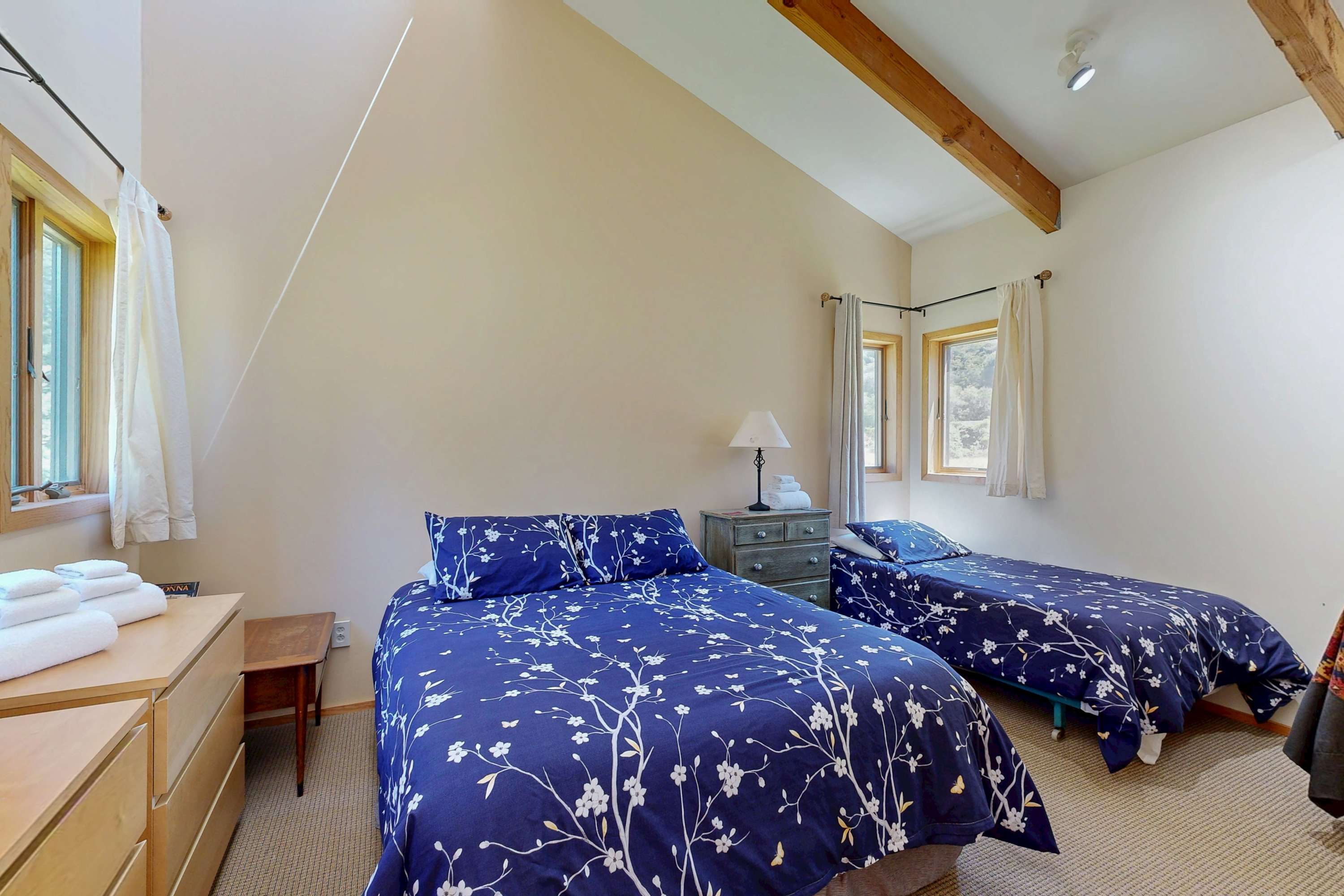 Retreat to the serene bedroom, featuring cozy bedding and ample natural light, inviting restful nights after your adventures.