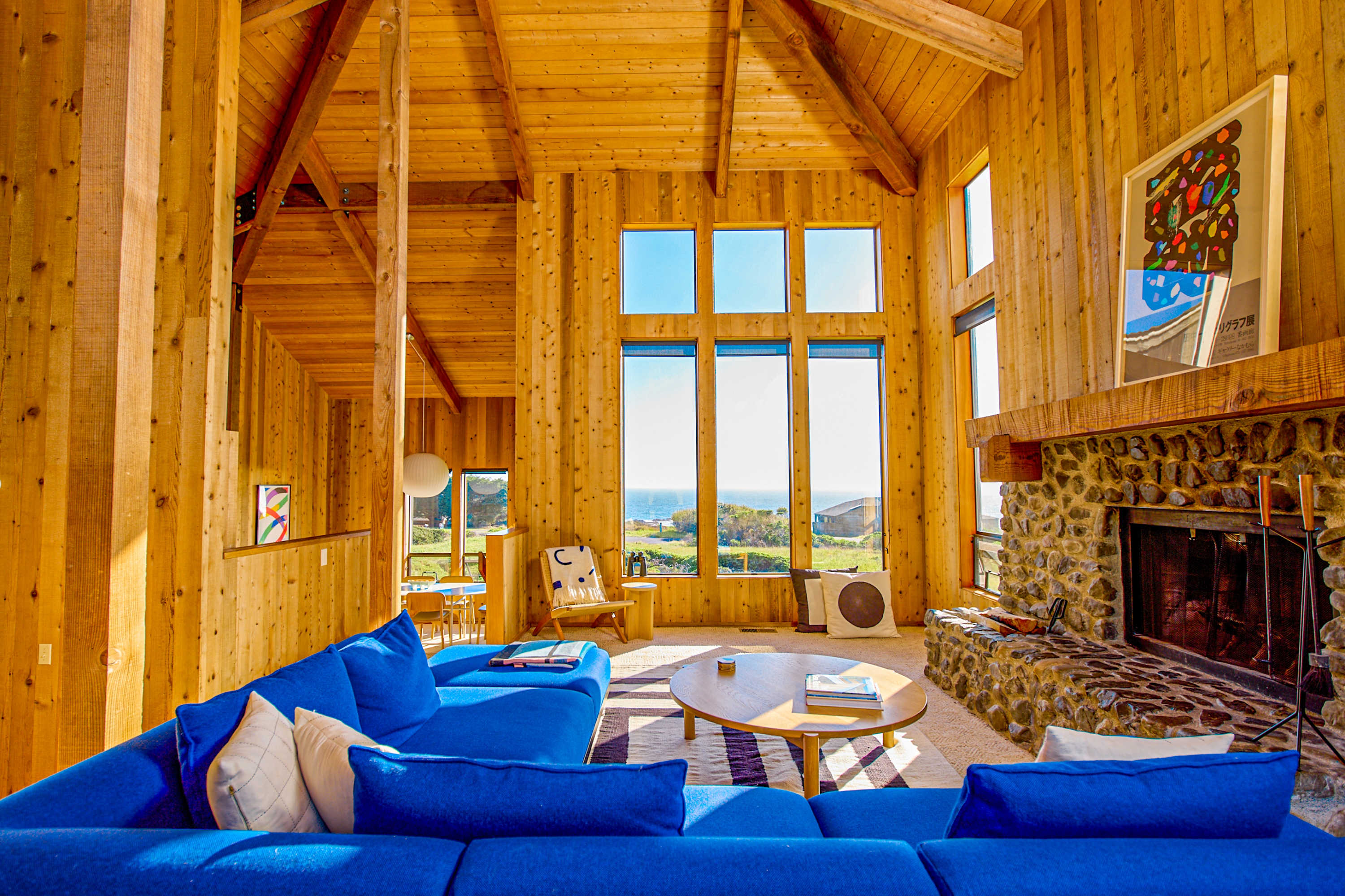 Bask in the warmth of the wood-burning fireplace as natural light pours through towering windows in this inviting living space.
