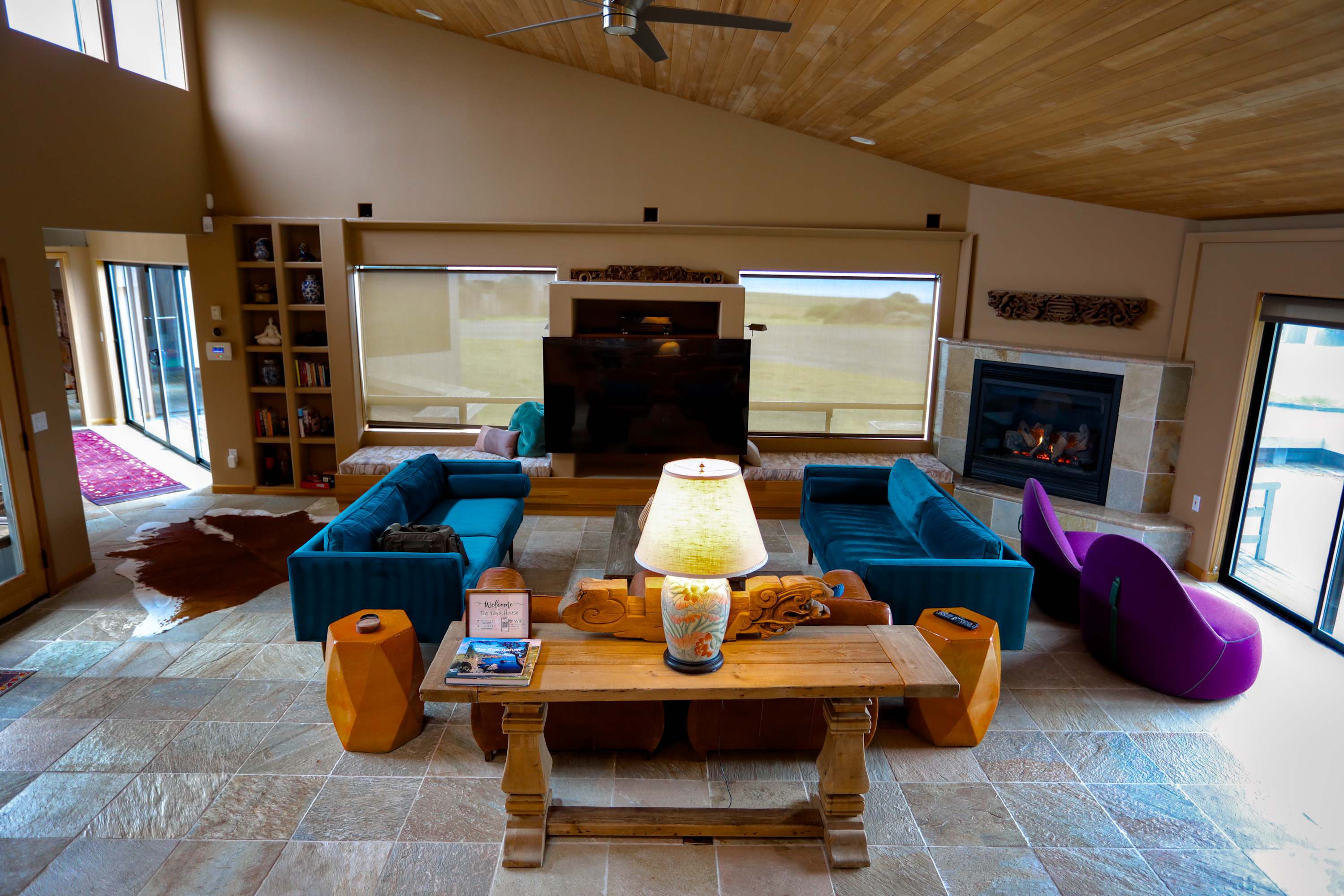 Vaulted wood ceilings and teal velvet sofas frame the living room — gather around the gas fireplace after a day on the bluff trail.