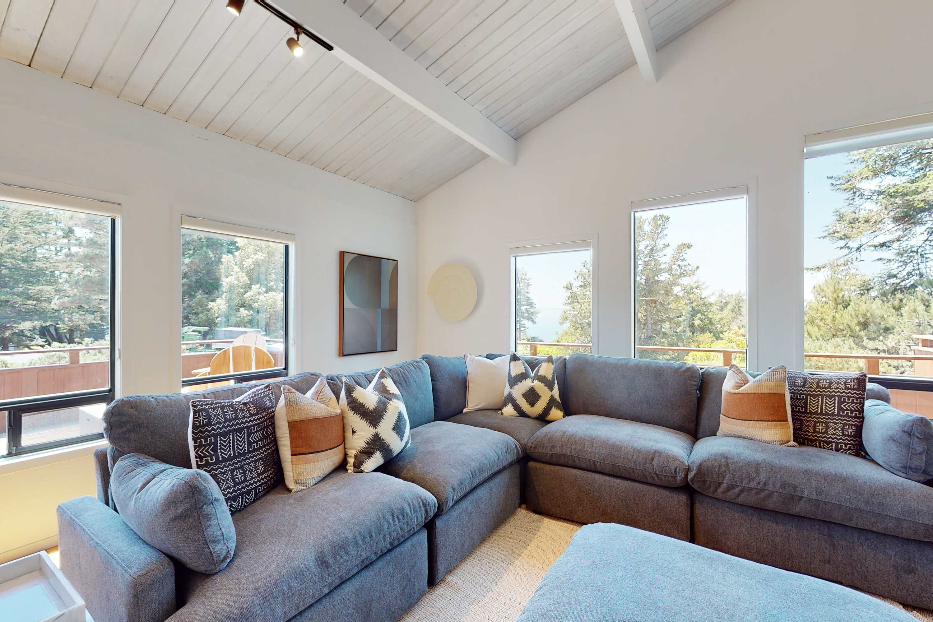 Curl up in the cozy corner of the living room, where plush seating and views of the trees create an inviting space for relaxation.