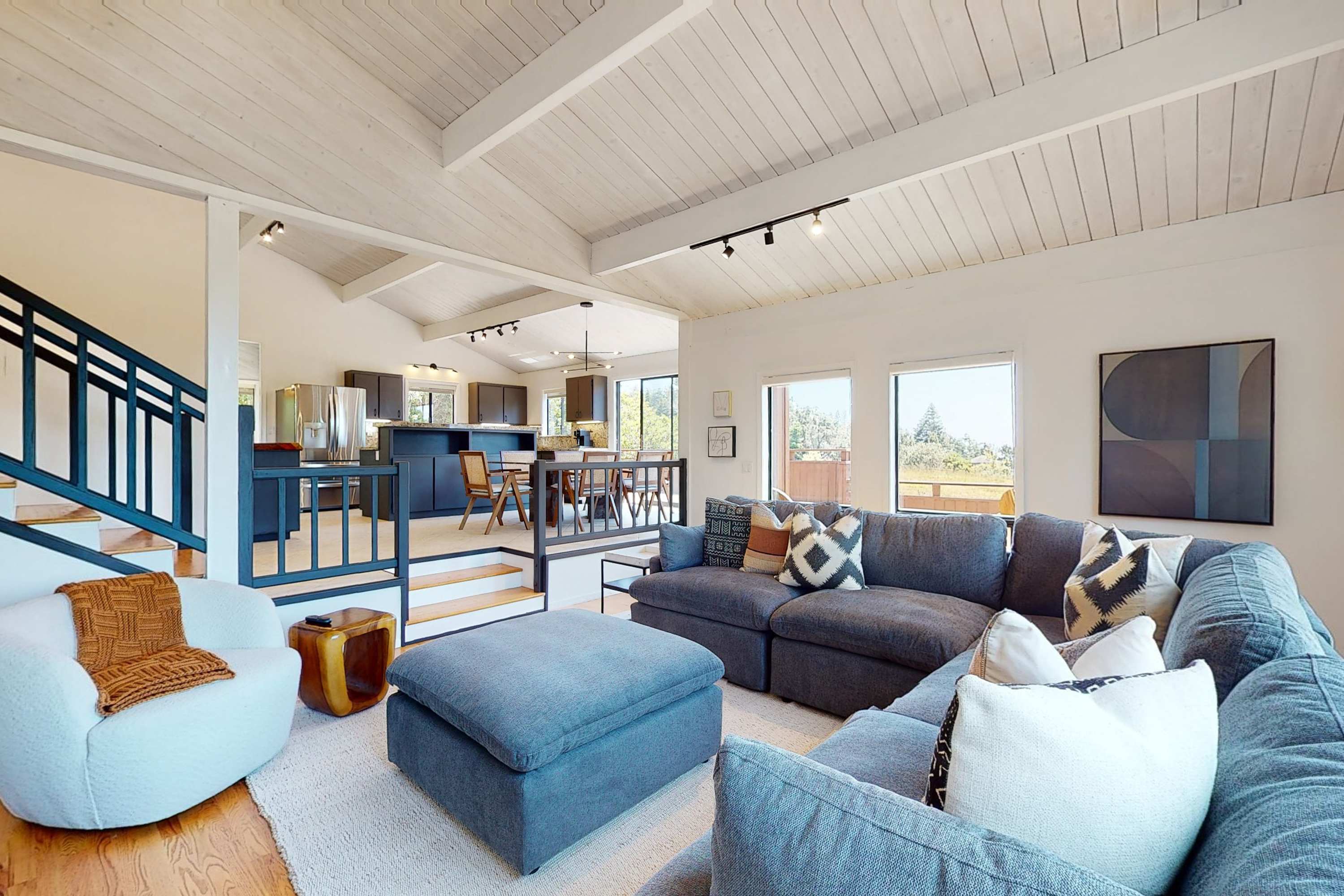 Gather around the spacious living room, where natural light streams through large windows, inviting laughter and conversation among friends and family.