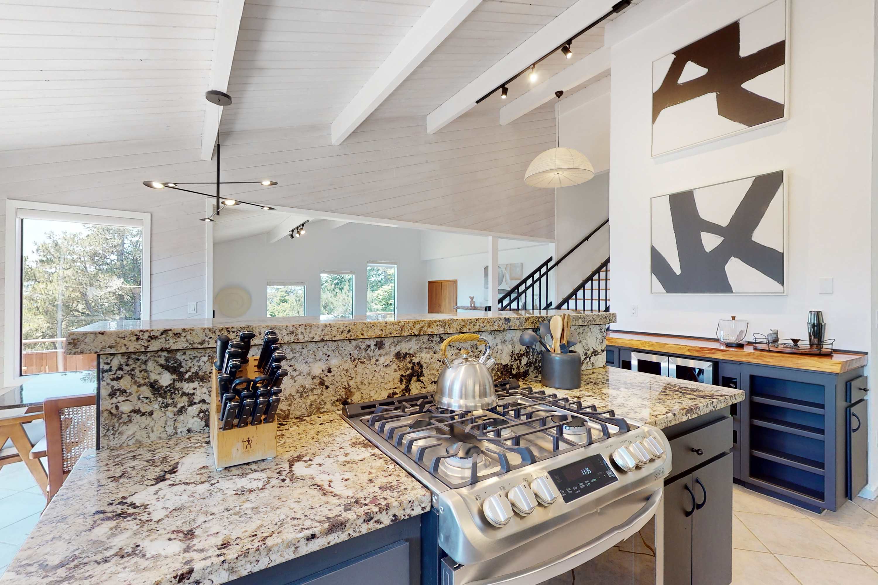 The kitchen's sleek design and gas range invite you to whip up delicious meals while enjoying the vibrant views just outside.