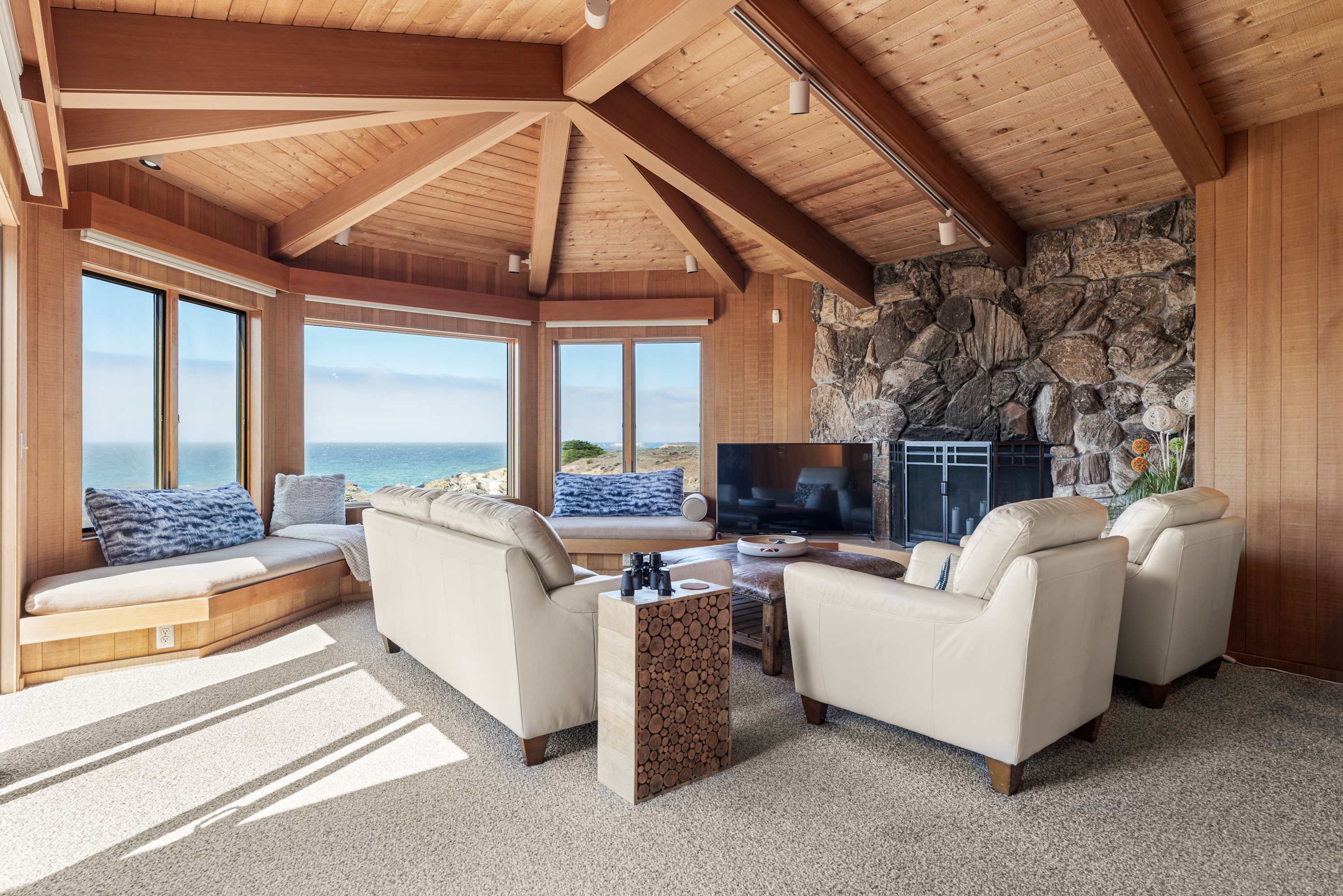 Set your coffee on the pebbled side table, angle a recliner toward the fire or the TV, and let the sun stripe the carpet.