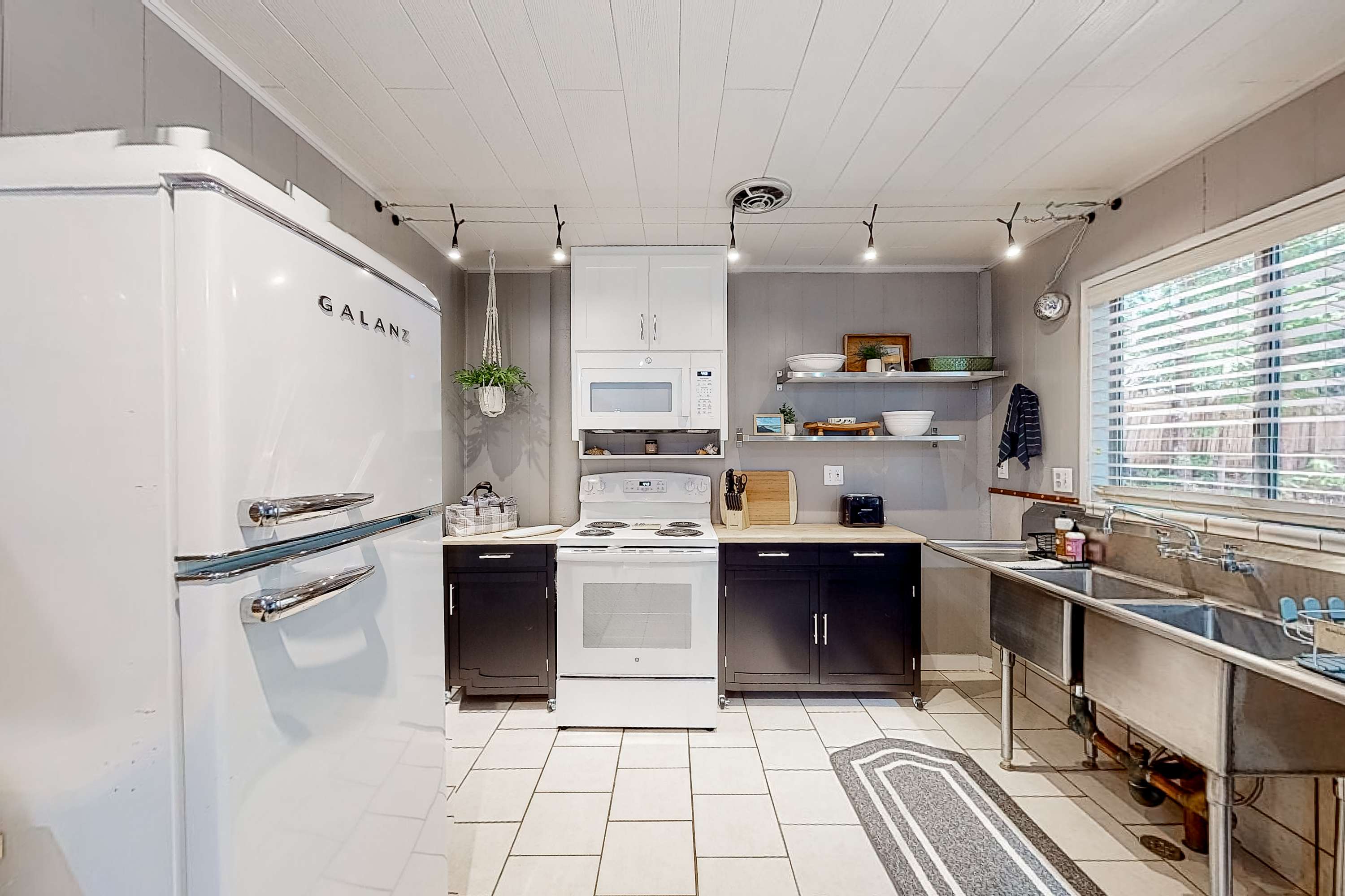 The kitchen’s retro charm invites you to whip up delicious meals while soaking in the cozy atmosphere, making every culinary moment memorable.