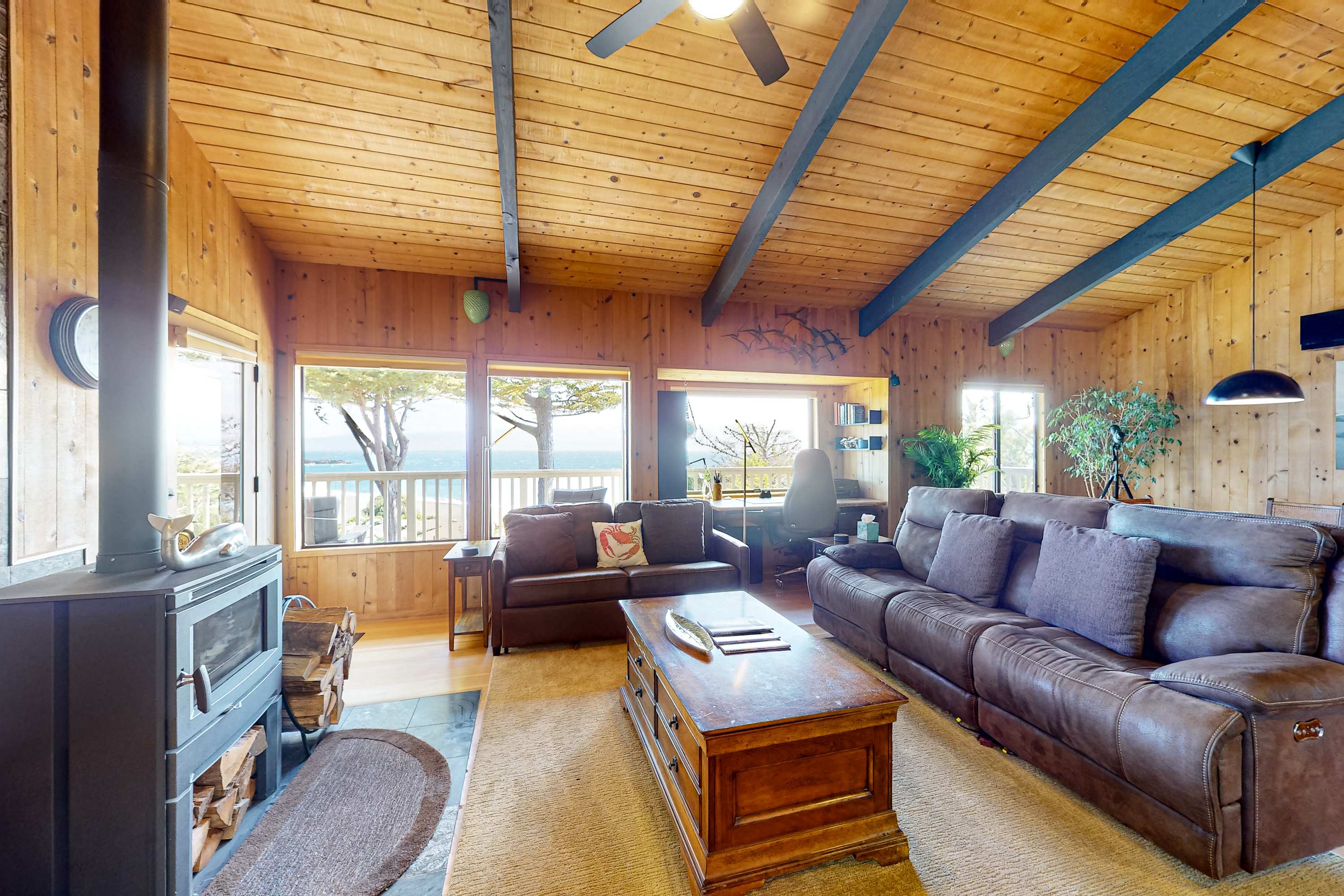 Relax by the fireplace in this comfortable living room, where every moment is elevated by the stunning coastal views.