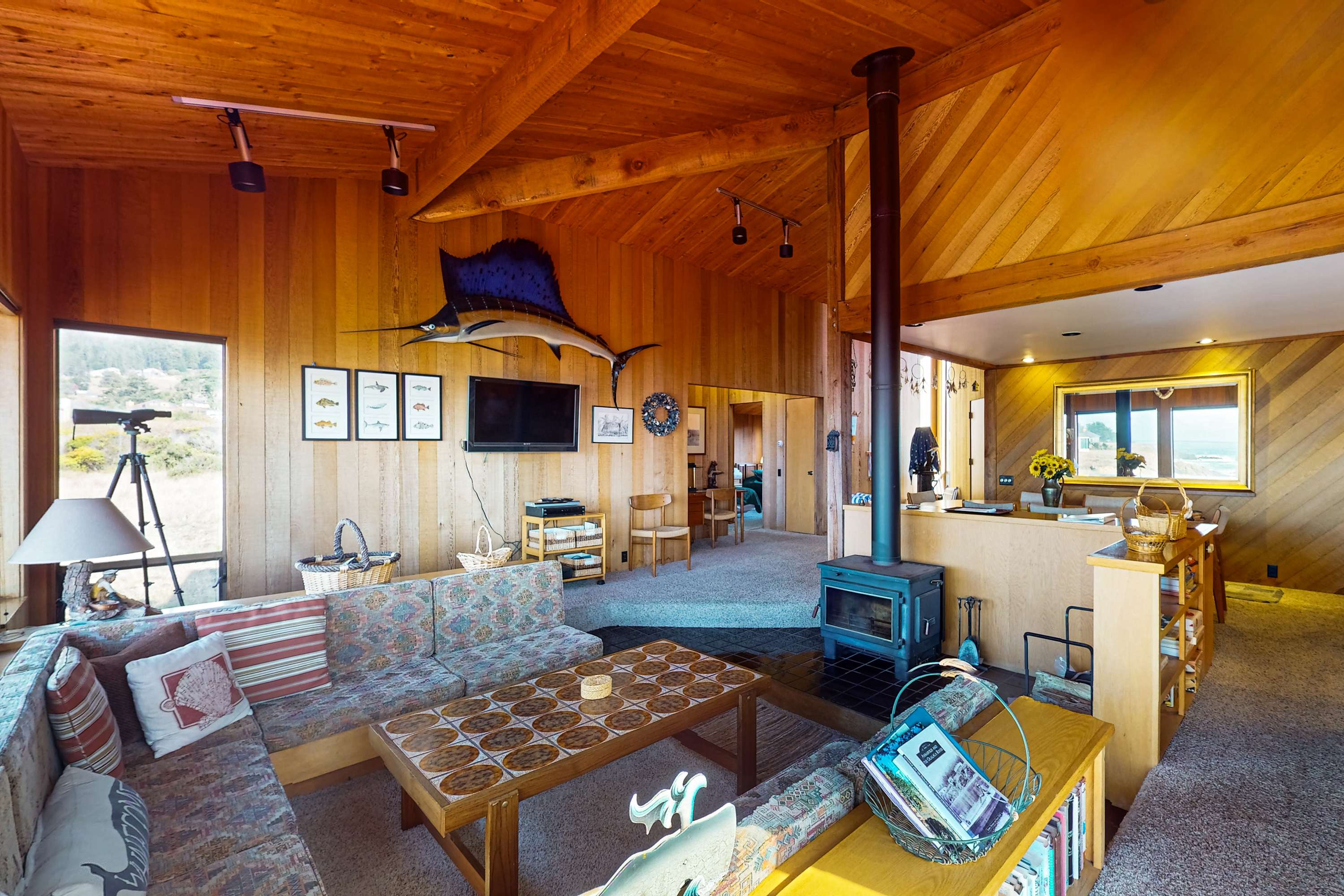 Gather around the cozy living space, where warm wood accents and a wood stove create the perfect ambiance for relaxation.