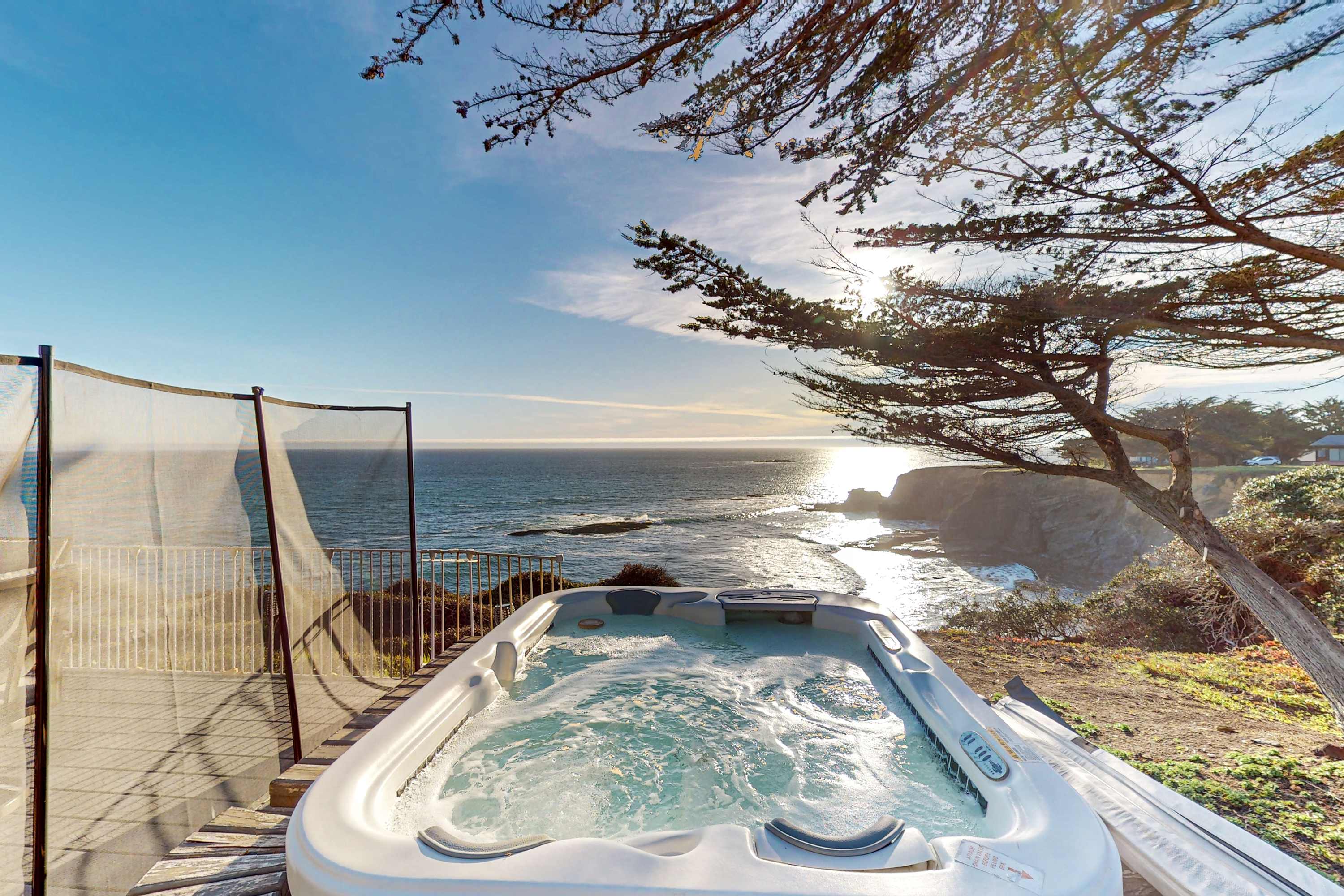 Soak in the private hot tub while watching the sun dip below the horizon, creating a magical coastal experience.