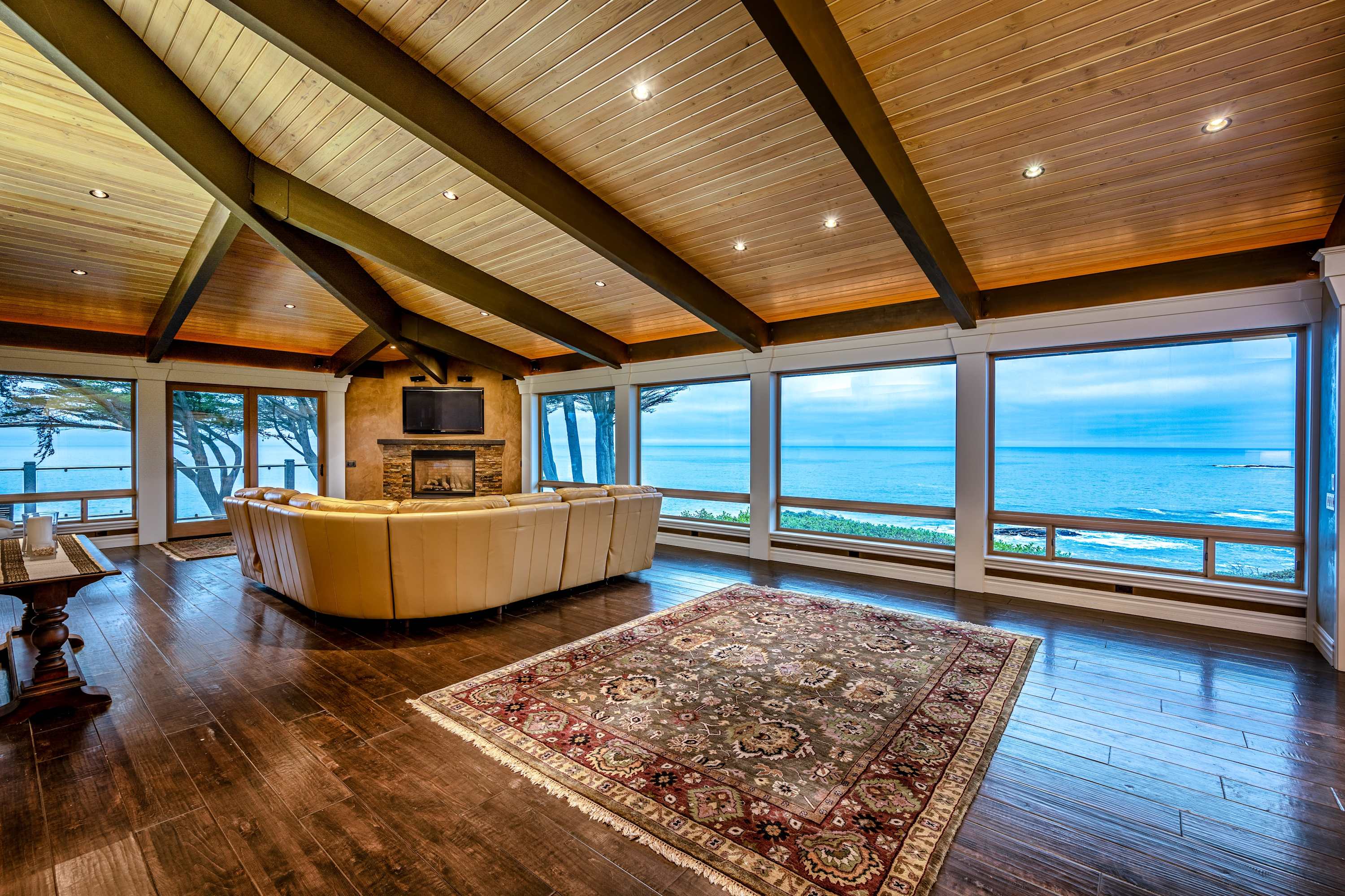 Imagine gathering with loved ones in this spacious living room, where floor-to-ceiling windows frame breathtaking ocean views.