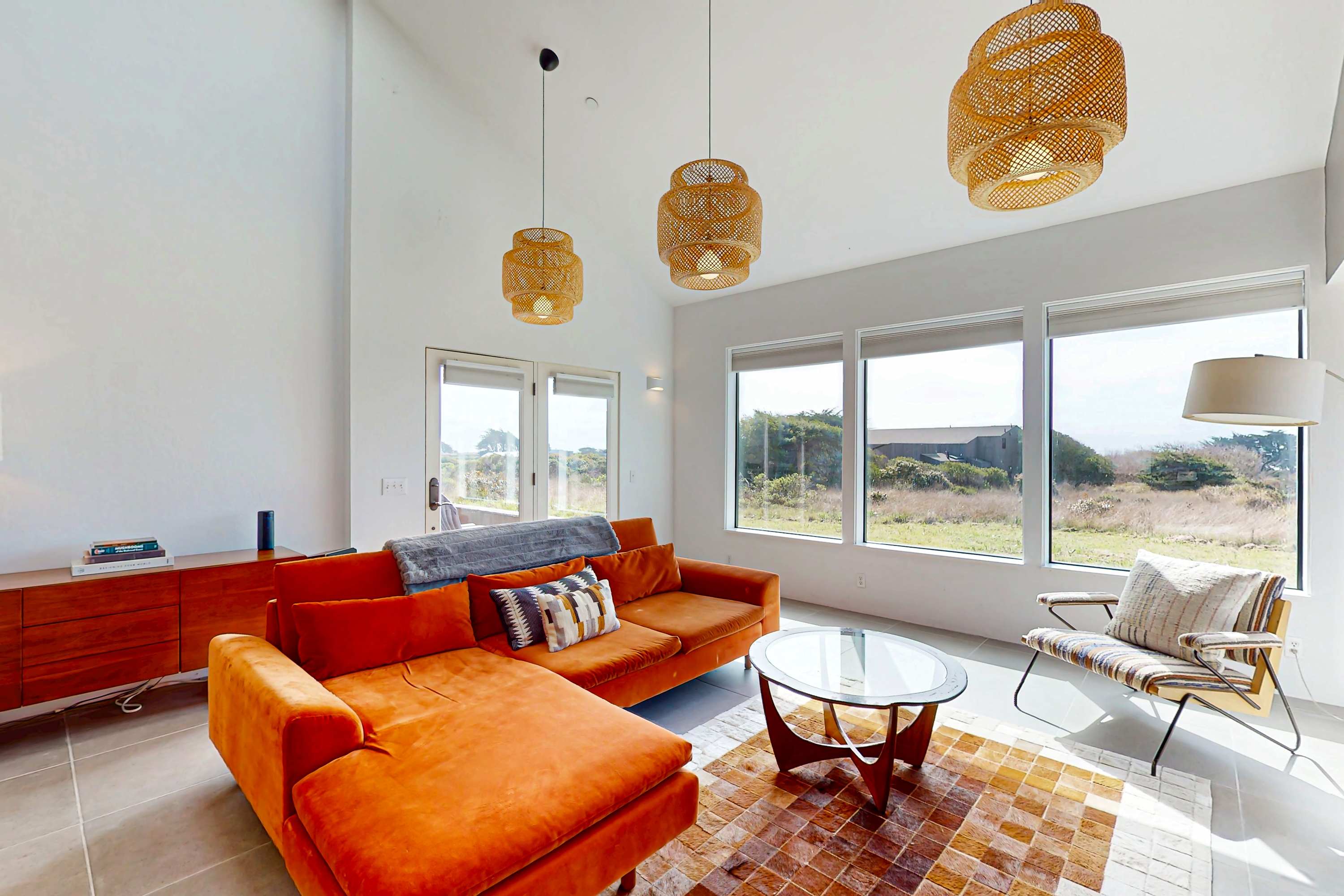 Relax in this beautifully designed living area, where you can enjoy the coastal views through expansive windows while basking in the afternoon light.
