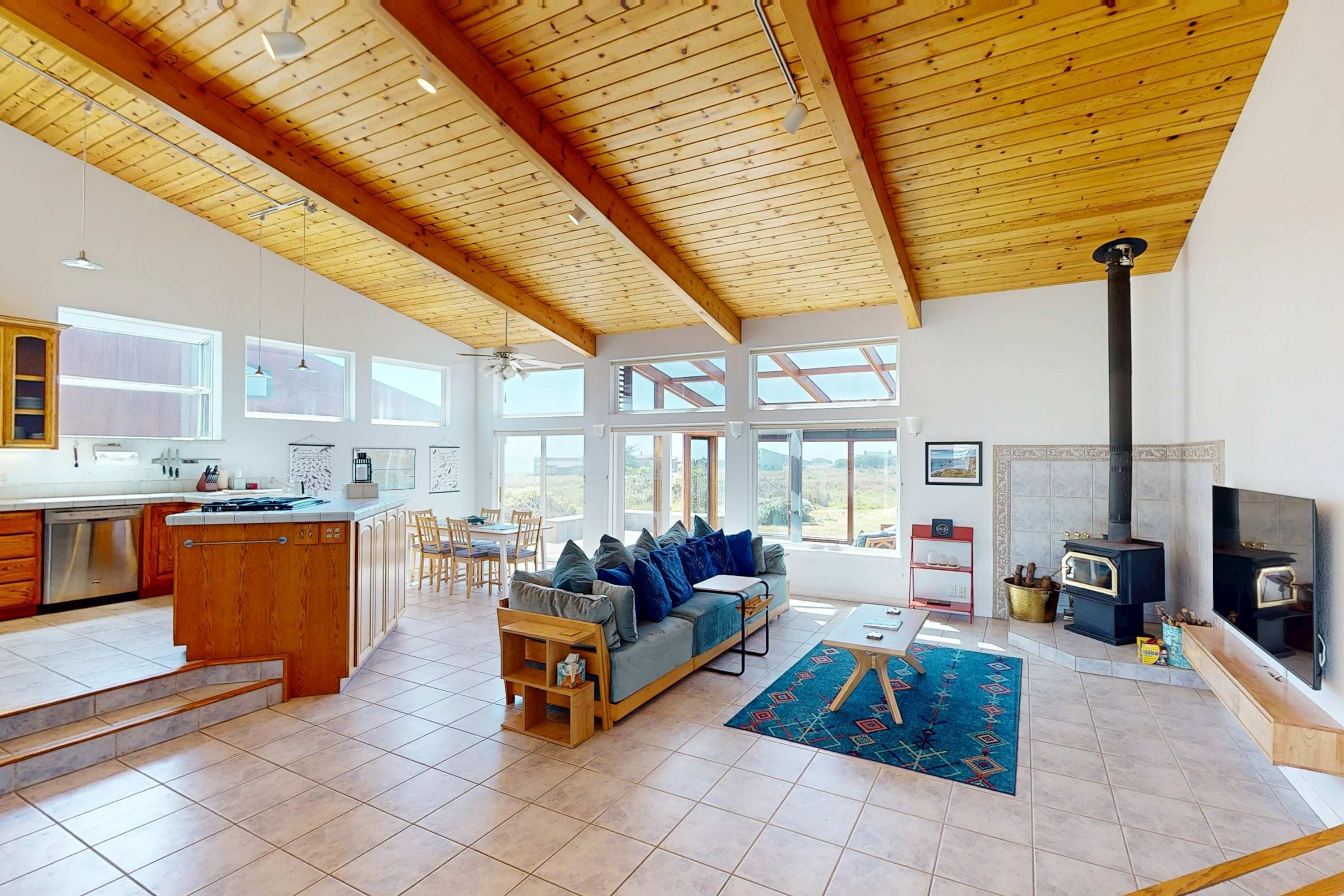 Gather in the spacious living room, where vaulted ceilings and natural light create an inviting atmosphere for unforgettable moments.