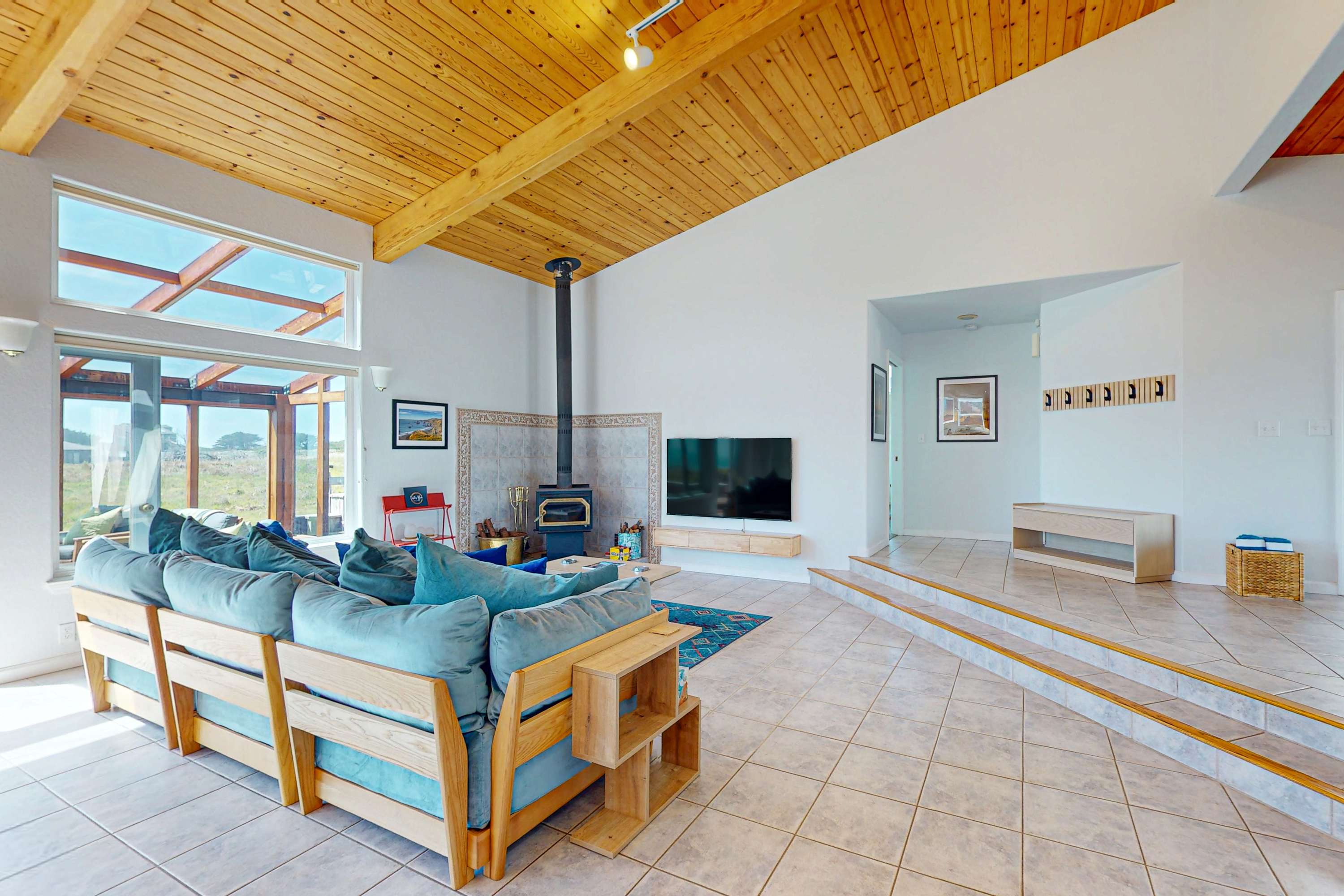 Cozy up by the wood stove in the living room, a perfect spot for sharing stories after a day of coastal adventures.