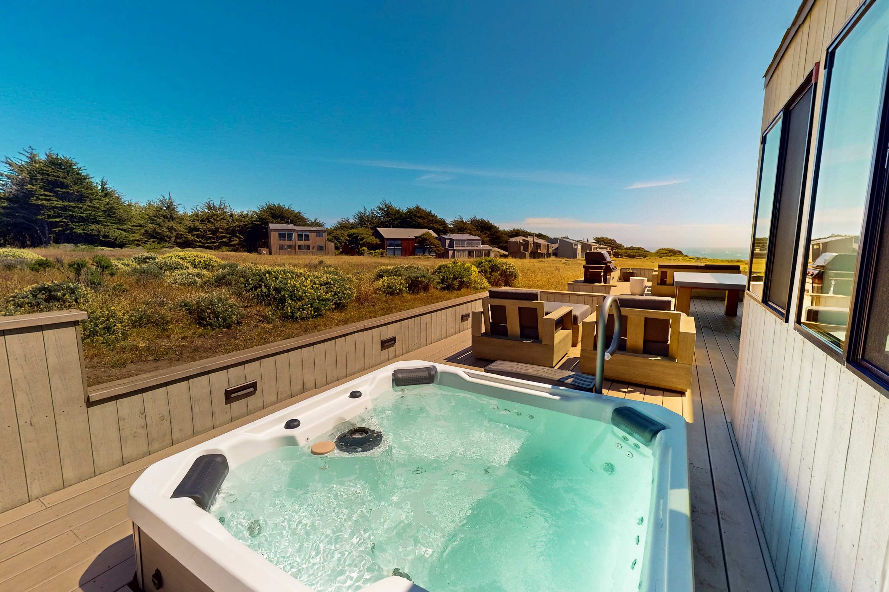 Relax in the private hot tub as you soak in the stunning coastal landscape around you.