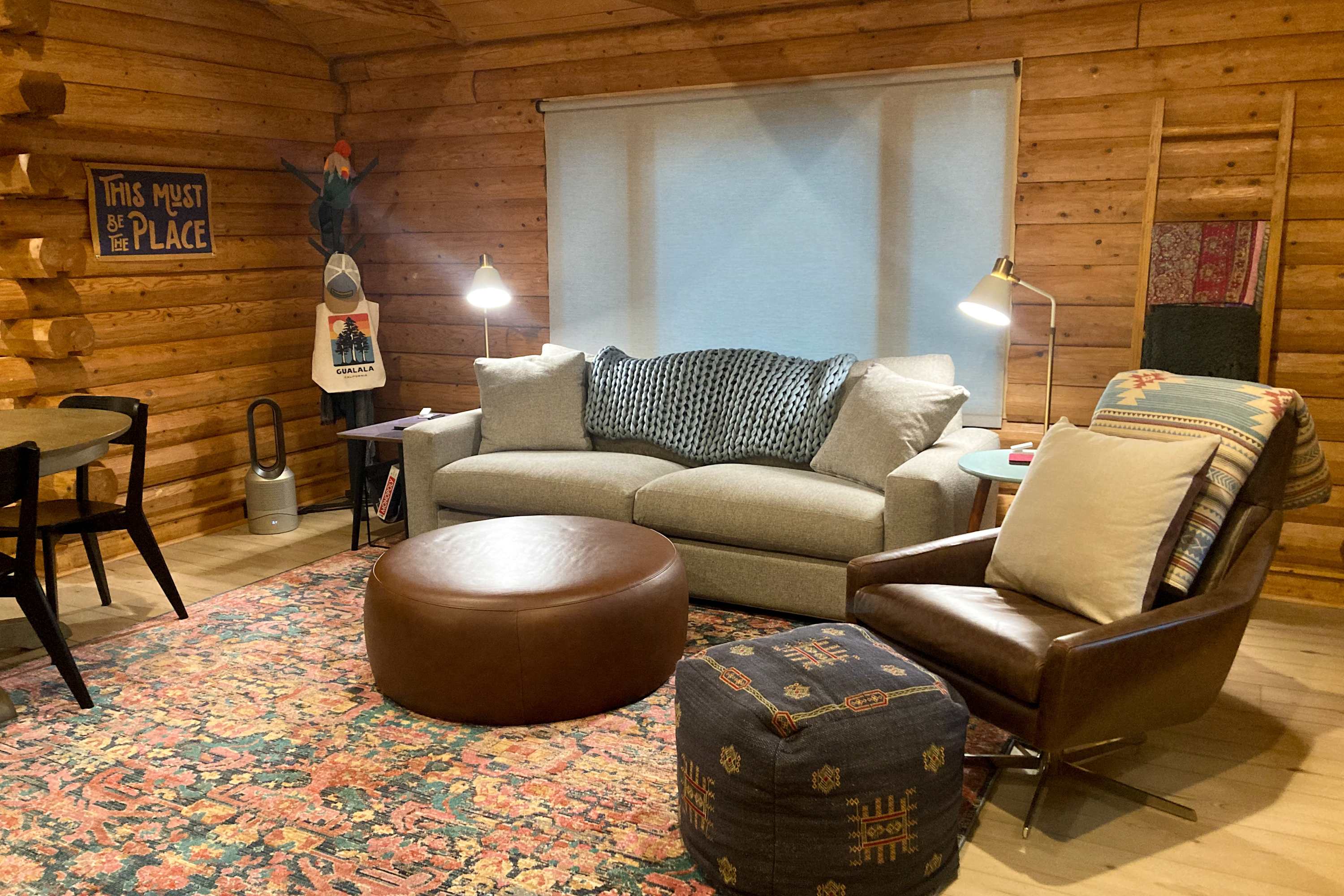 Bask in the warmth of the log cabin's living room, perfect for cozy evenings with friends or a quiet read by the window.