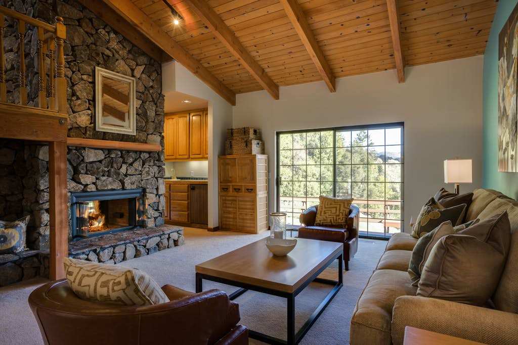 Sink into soft leather beside a crackling stone fireplace while the warmth of exposed wood beams wraps around you like wine country itself.