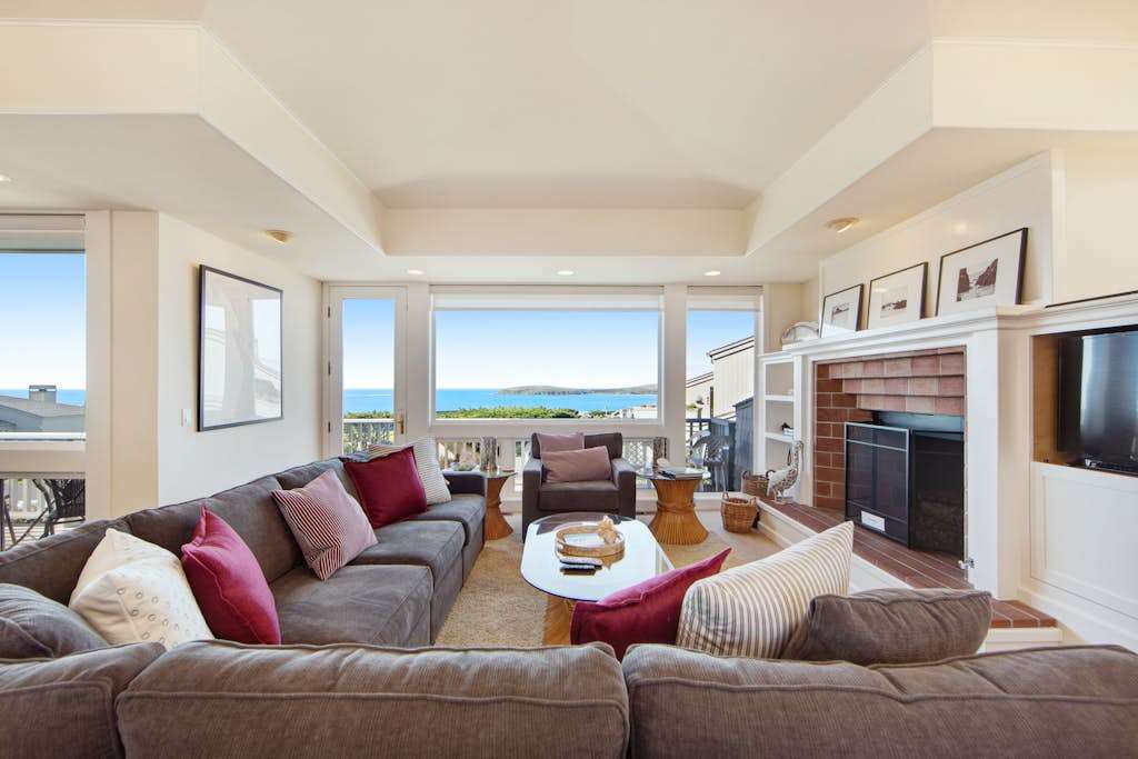 Panoramic ocean views flood the living room through floor-to-ceiling windows, creating your coastal living dream.