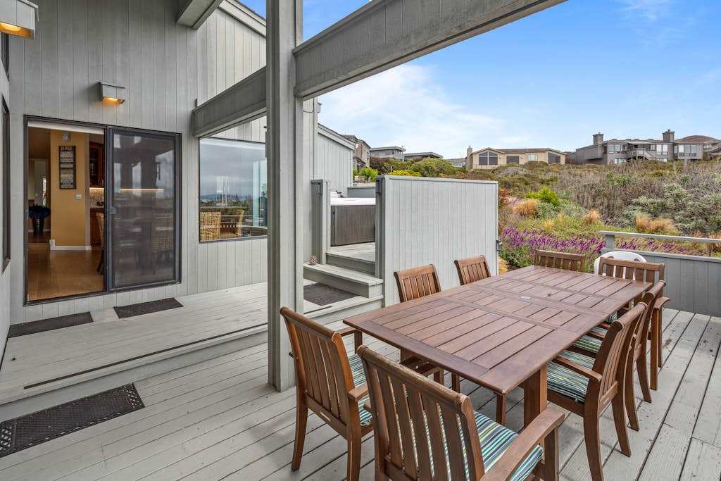 Dine outdoors on the sheltered lower deck, steps from the kitchen and surrounded by flowering coastal shrubs.