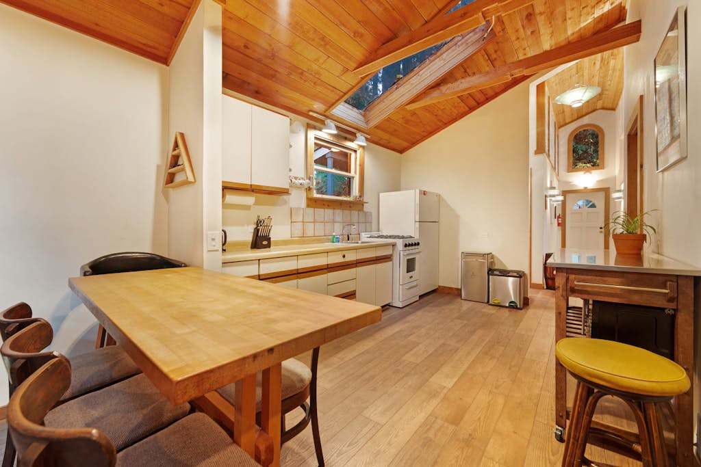 Bright natural light pours through the skylight onto your generous kitchen counter space beneath warm wood ceilings.