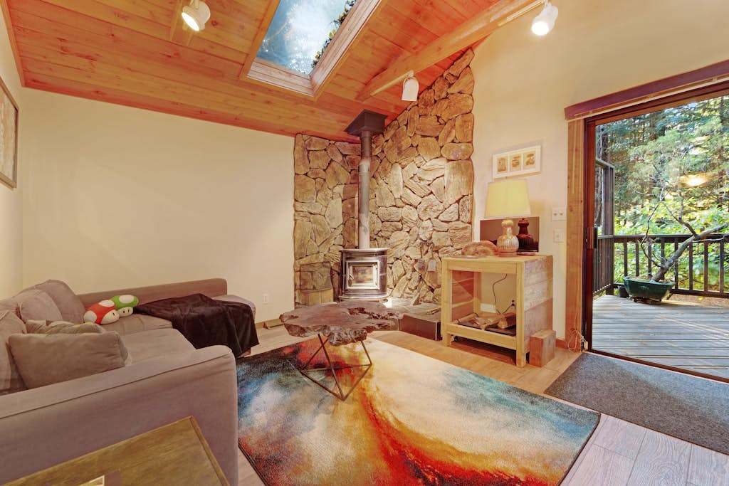 Cozy up by your wood-burning fireplace beneath soaring vaulted ceilings and a skylight that fills this redwood retreat with natural light.