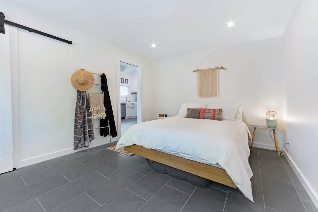 Slide the barn door closed for privacy in your inviting queen bedroom with soft textiles and warm lighting.