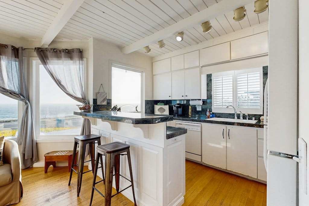 Cook with a view — your fully equipped kitchen features granite counters, breakfast bar, and Pacific Ocean vistas