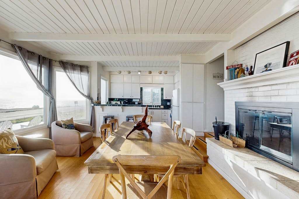 Enjoy dinner by the wood-burning fireplace in your open-concept living and dining space with ocean glimpses