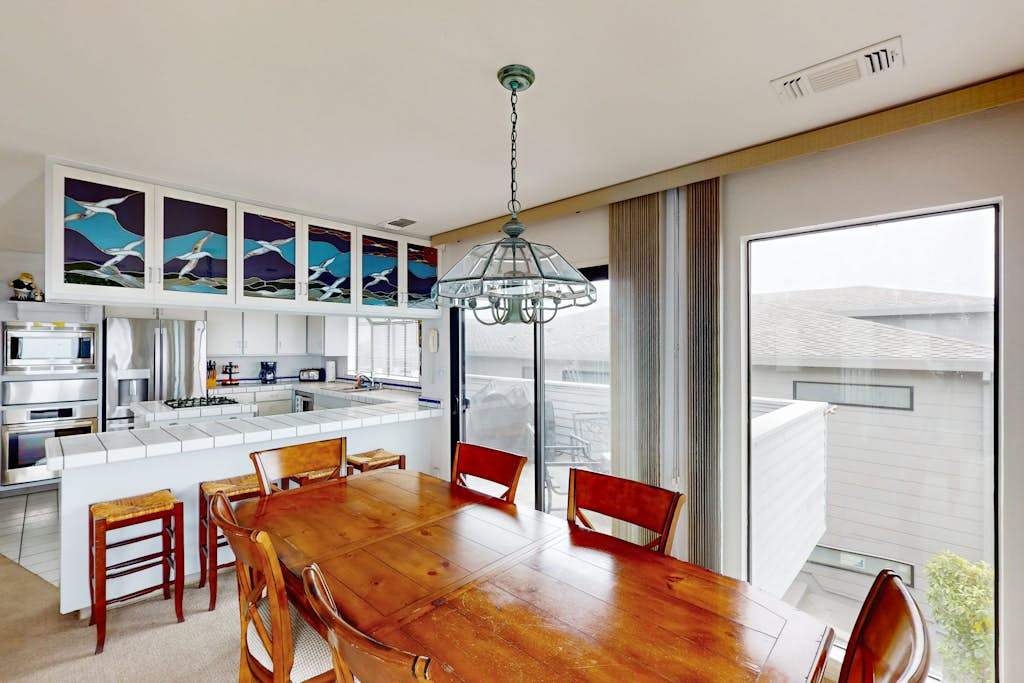 Share fresh Sonoma Coast seafood at your wooden dining table beneath artisan stained-glass panels capturing the colors of the Pacific