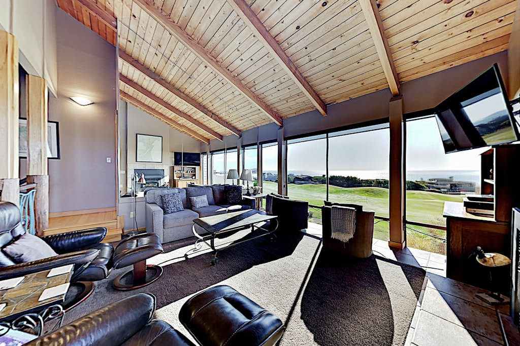 Spread out across multiple seating areas in this sun-filled great room — your floor-to-ceiling windows frame the golf course greens and distant Pacific blue.