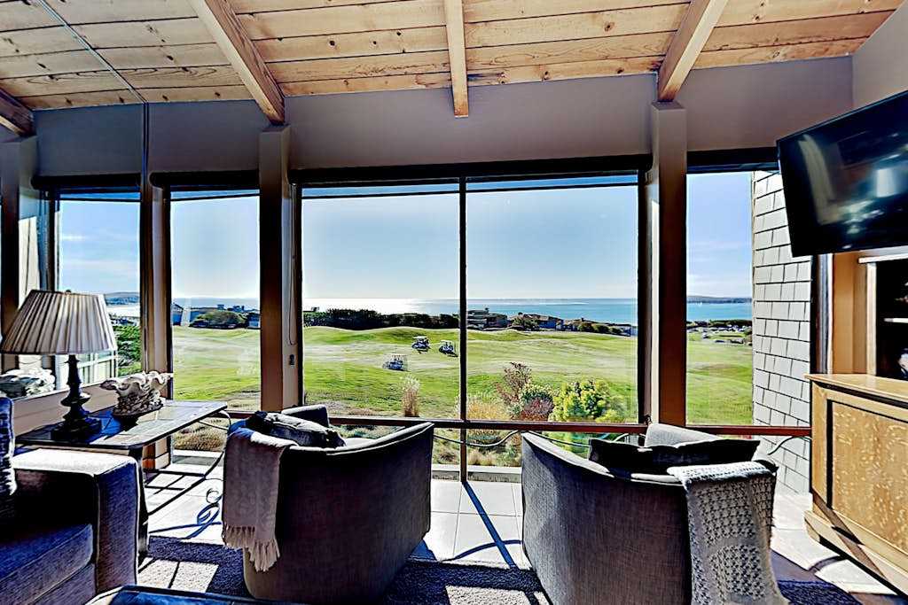 Your living room doubles as a private viewing lounge — watch Bodega Bay's coastal drama unfold through a wall of glass stretching from fairway to whitecaps.