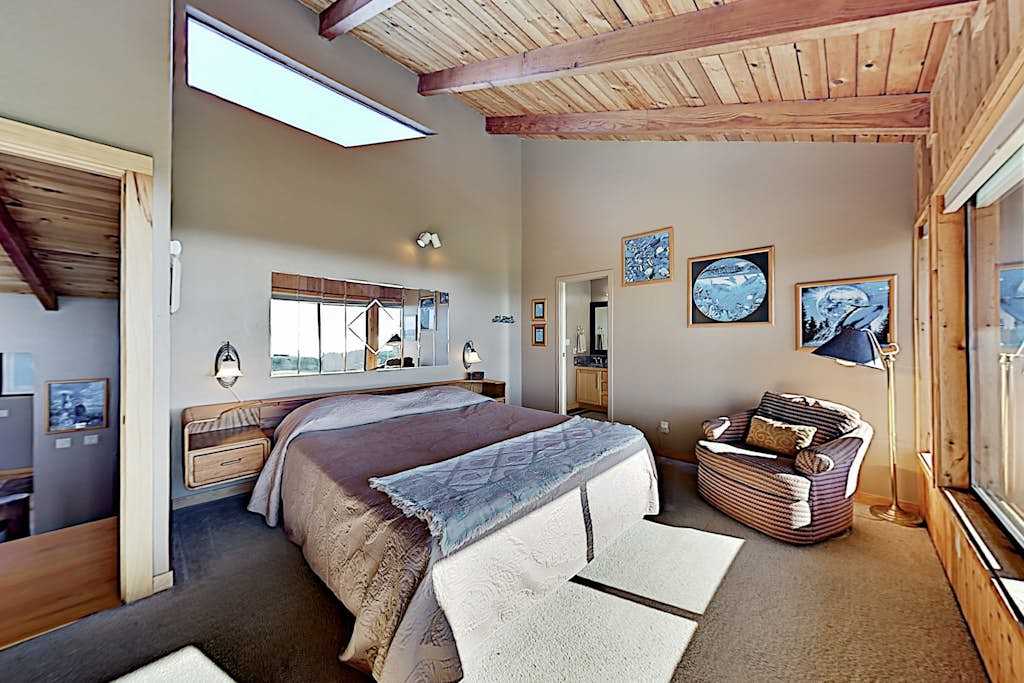 Wake to golf course panoramas and peeks of Pacific blue in this master suite — vaulted wood ceilings, a skylight, and a reading nook make mornings unforgettable.