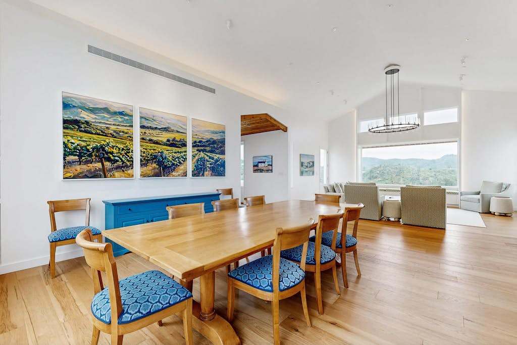 Gather your group around this elegant dining table beneath vineyard-inspired artwork — your private tasting room for unforgettable Sonoma wine country dinners.