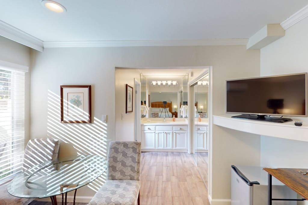 Plan your next Napa Valley winery visit from a bright, airy sitting area with modern furnishings and an entertainment center steps from the bathroom.