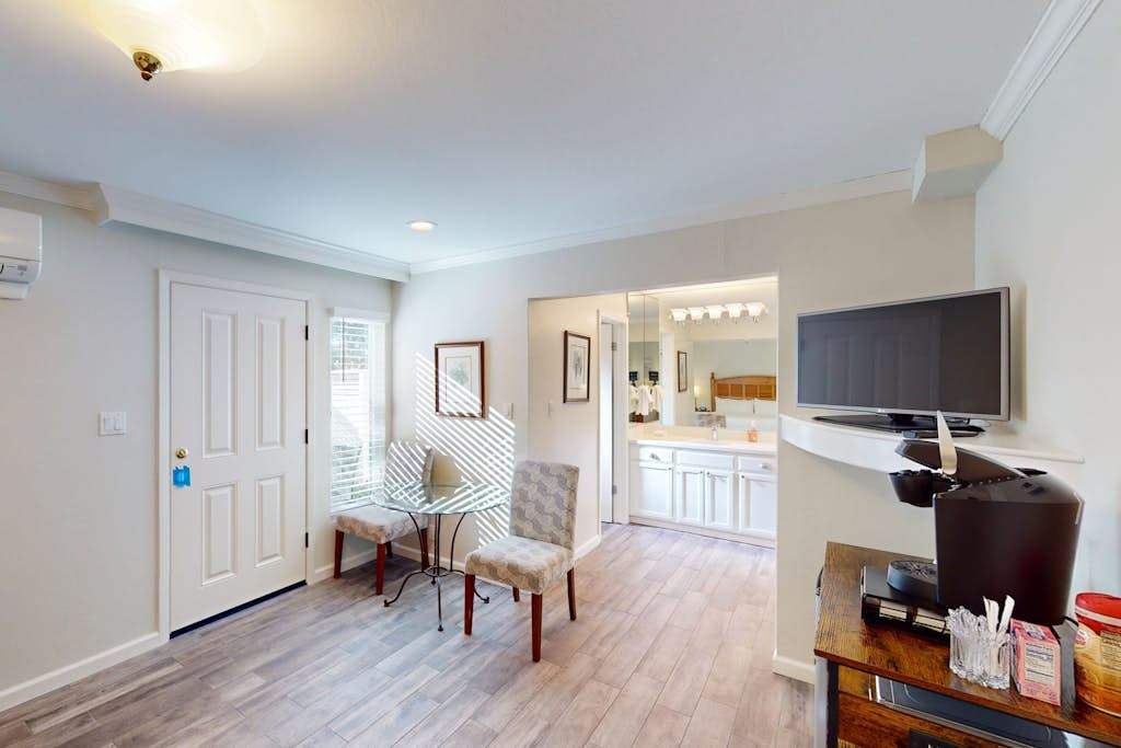 Unwind in your open-plan living space with stylish striped armchairs and a wall-mounted TV — your Napa Valley home base between vineyard adventures.