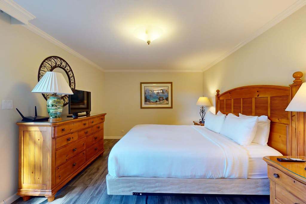 Drift off in crisp white linens atop your king bed, framed by warm wood furnishings that echo Napa Valley's rustic elegance.