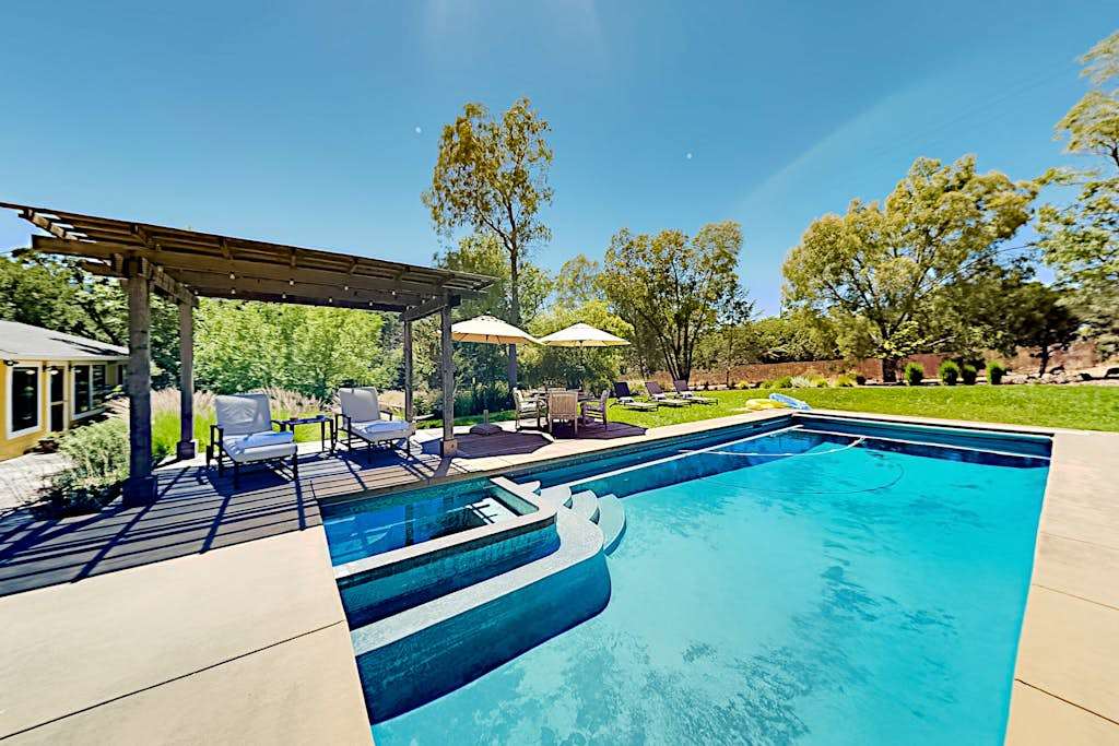 Dive into your private Glen Ellen oasis — a sparkling heated pool and built-in hot tub await beneath the pergola, with sun loungers ready for your wine country afternoon.