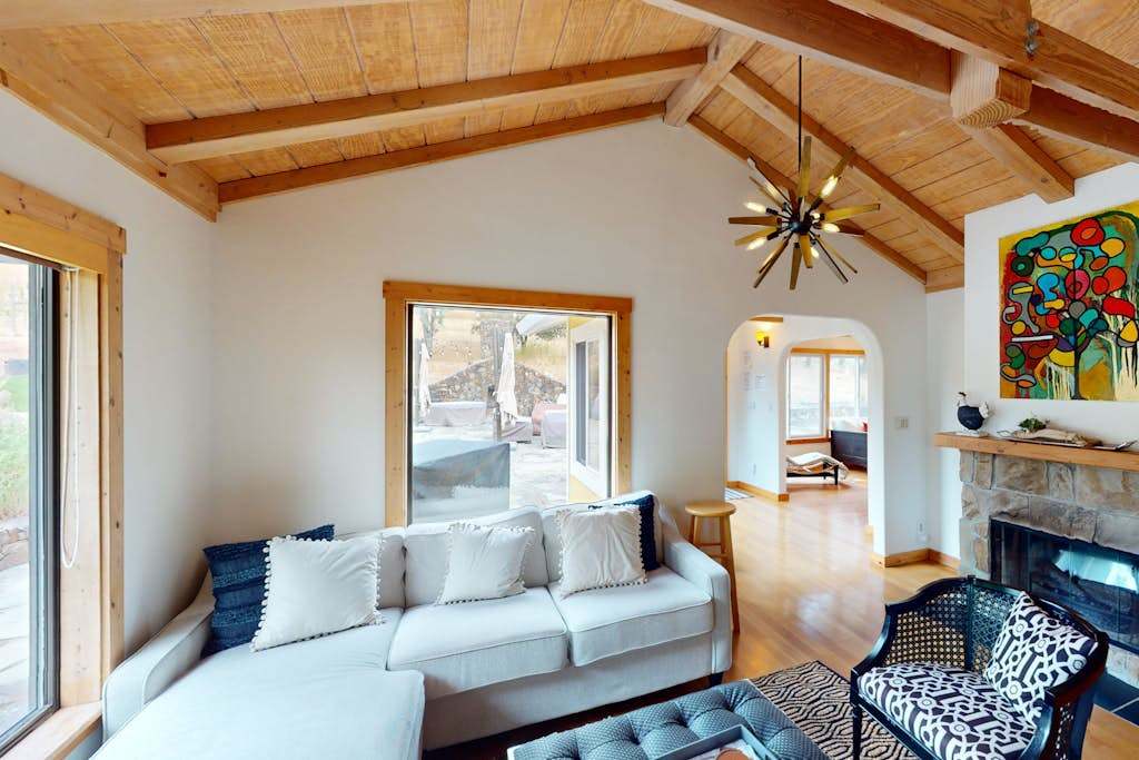 Curl up by the stone fireplace in your cozy family room — a mid-century sputnik chandelier and bold local art add Sonoma creative flair.
