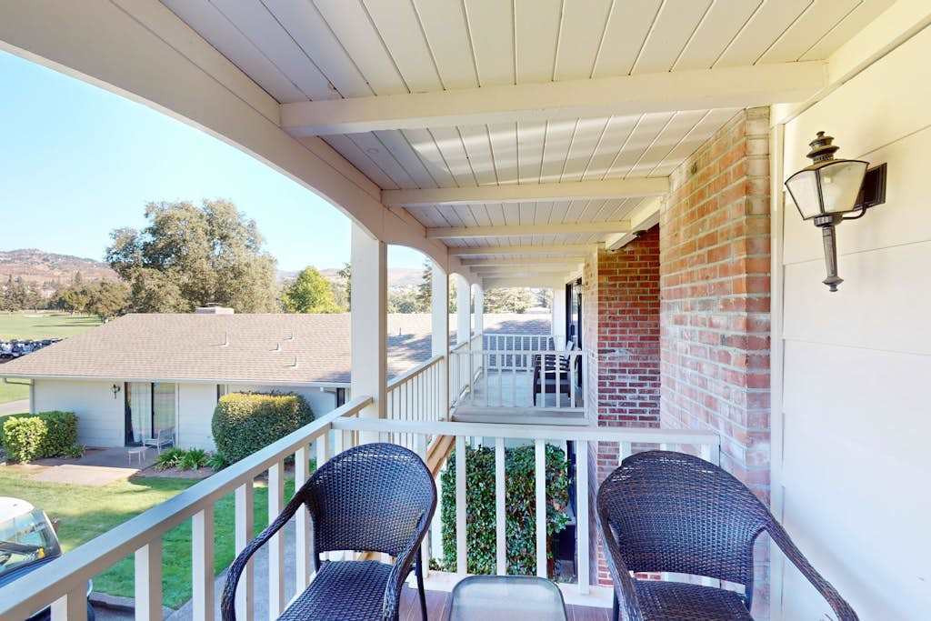 Relax on your covered porch with wicker seating and charming lantern lighting — an inviting spot to enjoy a glass of your favorite Napa pour.