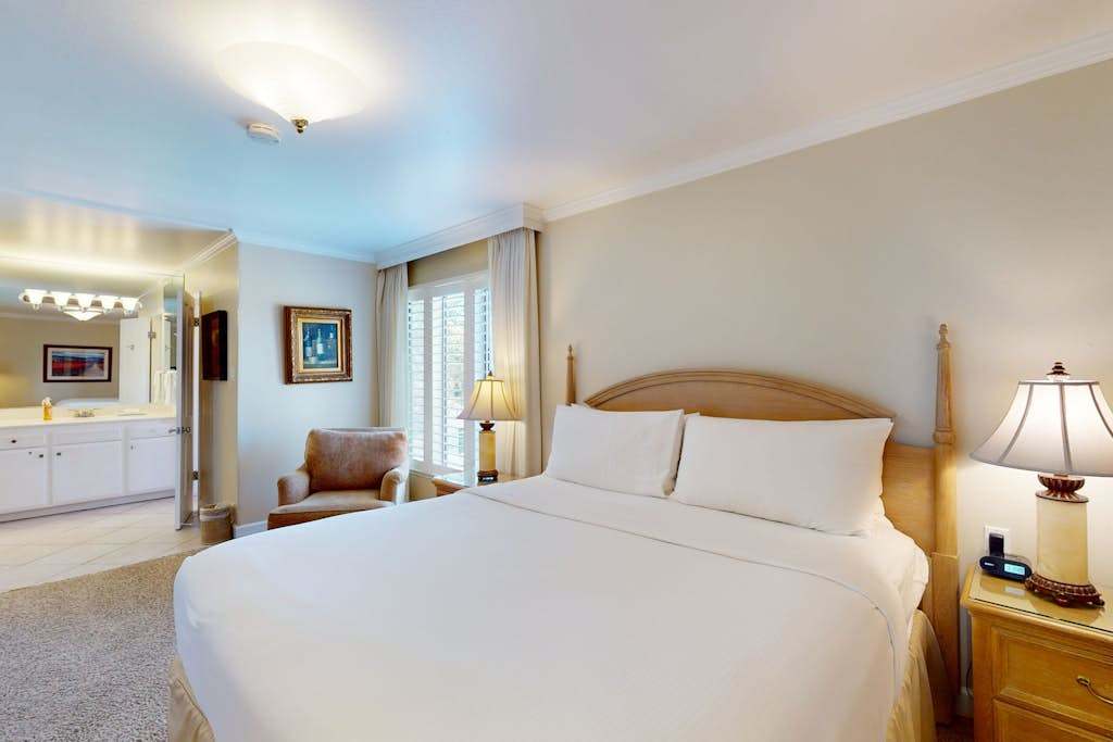 Rest your head on crisp white linens in your resort-style king bedroom — natural light filters through plantation shutters for a serene Napa morning wake-up.