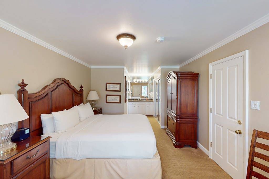 Sink into your plush king bed with crisp white linens — elegant wood furnishings set the tone for a restful Napa getaway