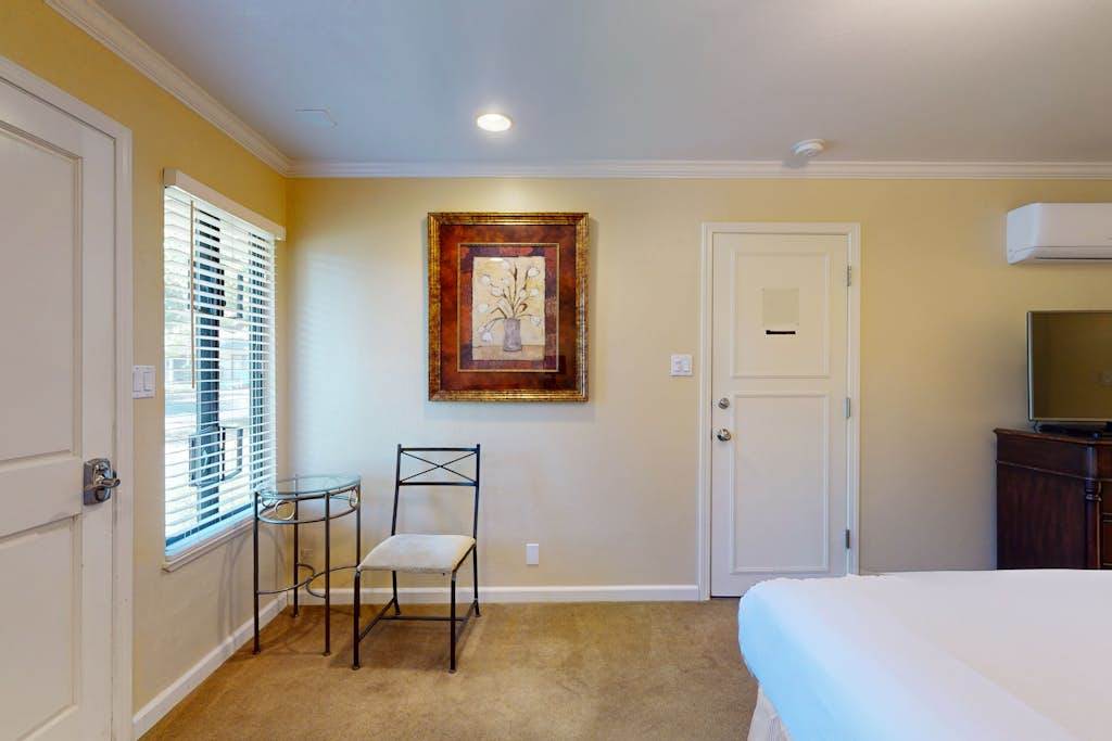 Tasteful artwork and a reading nook invite you to unwind in your Napa Valley bedroom — modern air conditioning keeps your suite perfectly comfortable year-round.