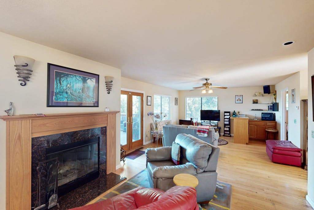 Settle into your sun-drenched living room where a stone fireplace anchors the open floor plan — perfect for unwinding after a day exploring Cloverdale wineries.