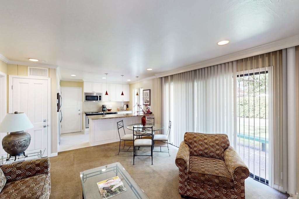 Enjoy your open-concept Napa retreat where the living area flows seamlessly into a modern kitchen and dining space, with natural light streaming through floor-to-ceiling windows.