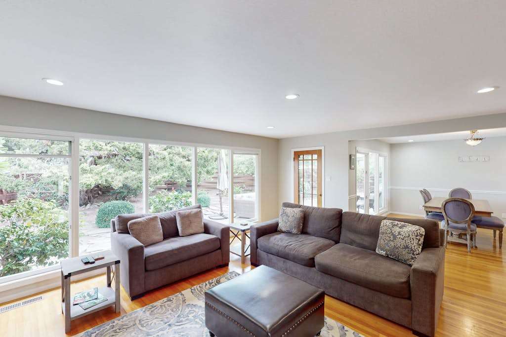 Stretch out in your sun-filled living room where floor-to-ceiling windows frame garden views — hardwood floors and comfortable seating invite you to relax between vineyard visits.
