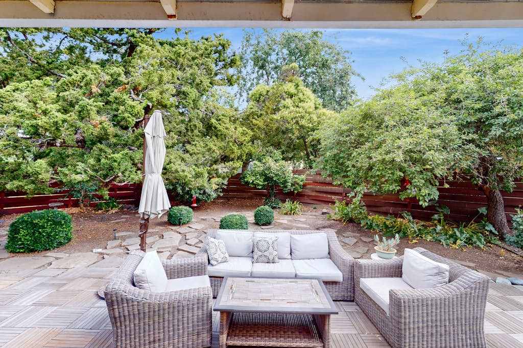 Unwind on your private patio surrounded by lush Sonoma greenery — plush wicker seating and a shaded umbrella create the perfect spot to sip local wines after a day of tasting.