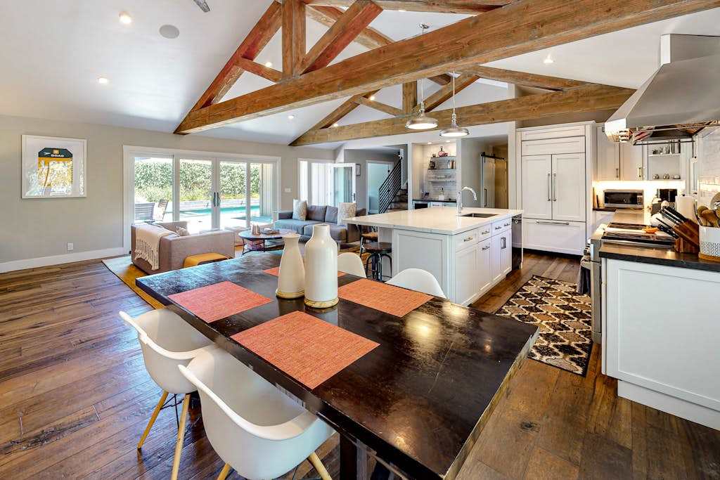 From your farmhouse dining table, watch the chef work the open kitchen — exposed beams and a generous island connect every guest to the conversation.