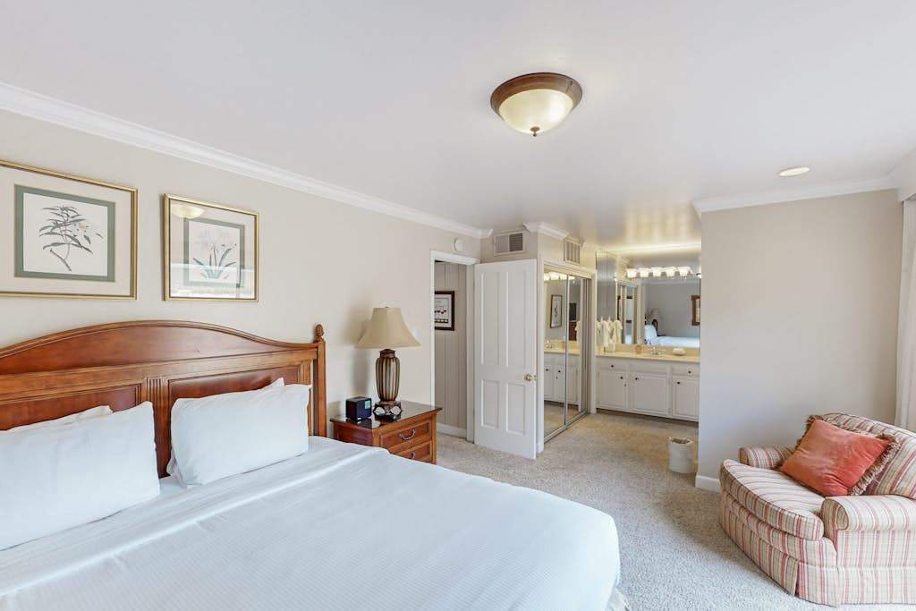 Enjoy the suite life with your king bedroom flowing into an ensuite bath — a comfortable armchair by the patio makes for the perfect reading nook