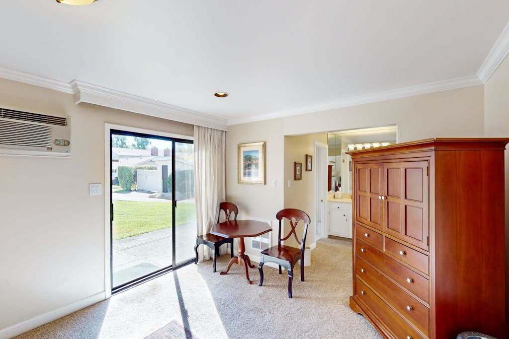 Step from your bedroom directly onto the patio through sliding glass doors — a cherry armoire and bistro table make this Napa hideaway feel like home.