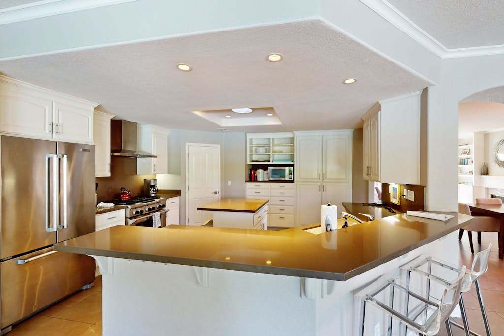 Channel your inner chef in this fully equipped gourmet kitchen with a wraparound island, stainless steel appliances, and room for everyone to pull up a stool.