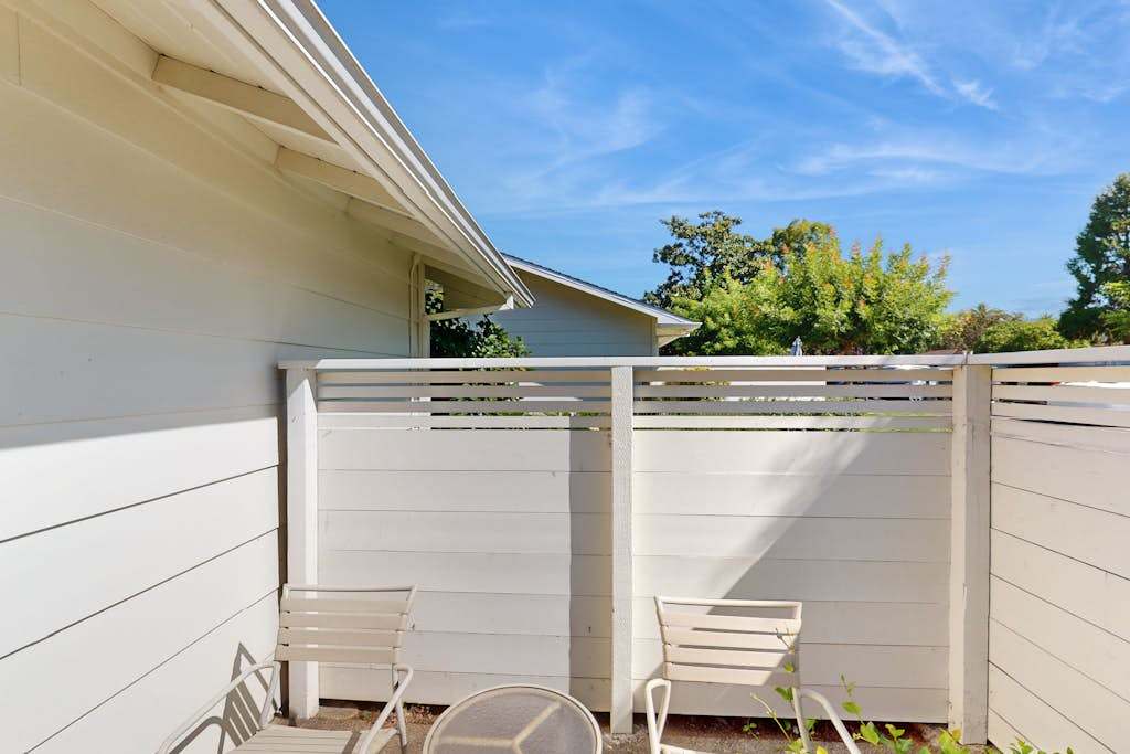 Sip your favorite Napa Valley pour on your private enclosed patio — a secluded outdoor space with chairs and blue-sky views between the resort's cottage-style buildings.